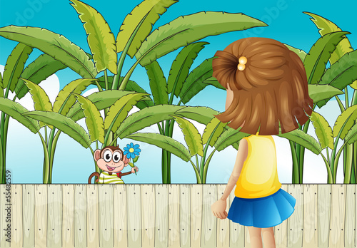 A girl and a monkey near the wooden fence
