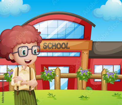 A boy with a school building at his back