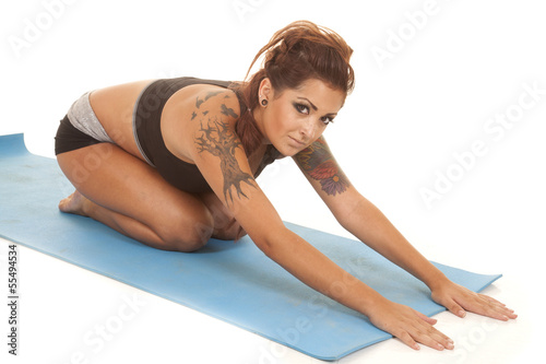 Woman tattoos childs pose looking