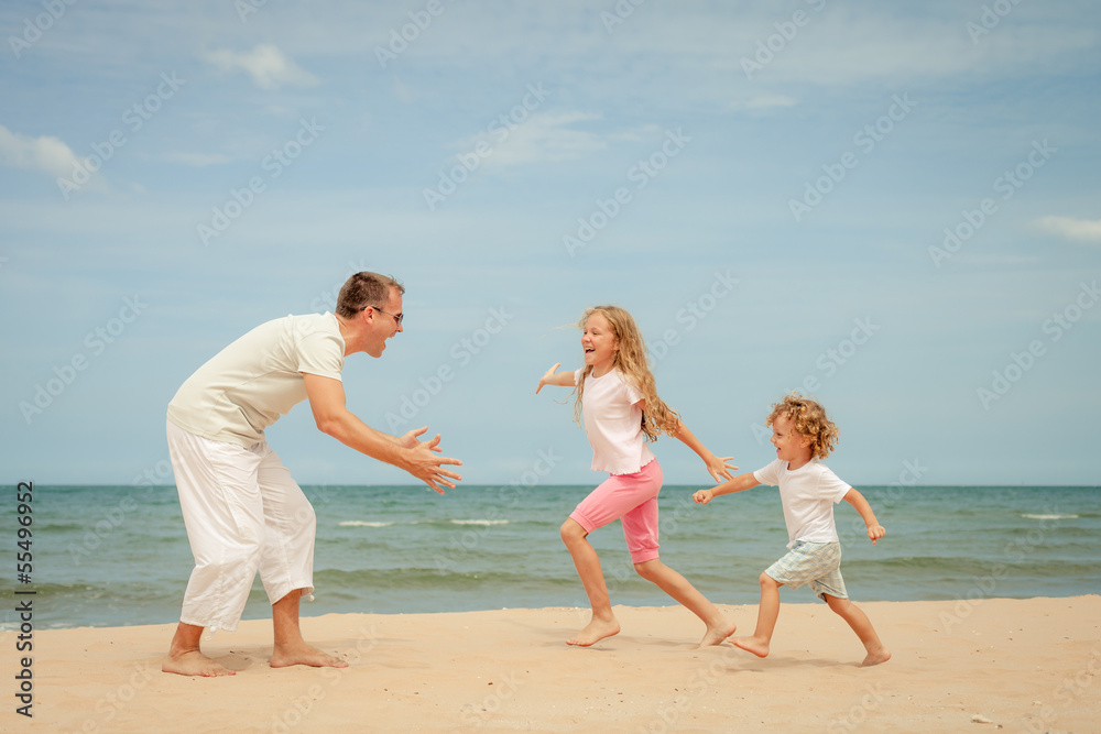 Happy family playing at the beach in the day time