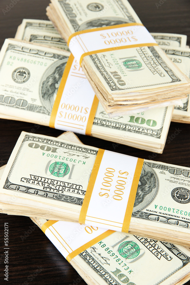 Stacks of money on wooden table Stacks of money on wooden table