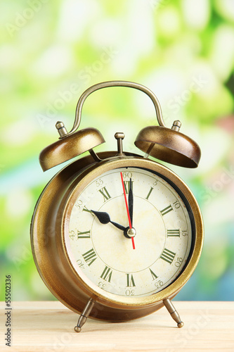 Old alarm clock on bright background