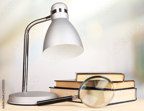 Table lamp and books on desk in room photo