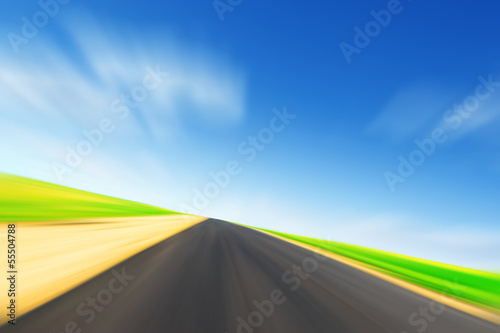 Asphalt road in motion blur and blue sky. © Elena Volkova