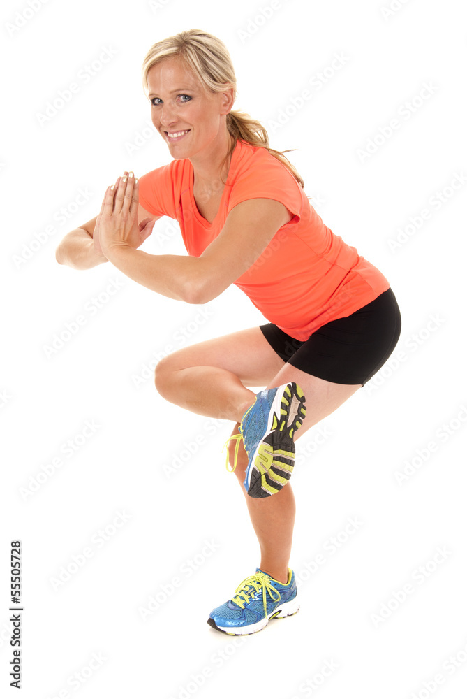 Attractive woman in yoga pose working out in orange top Attractive woman in yoga pose working out in orange top