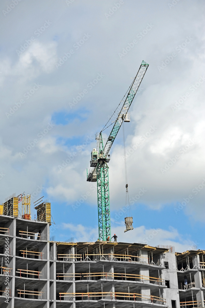 Crane and building construction site against blue sky Crane and building construction site against blue sky