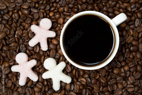 background of coffee beans with cup of coffee and sugar closeup