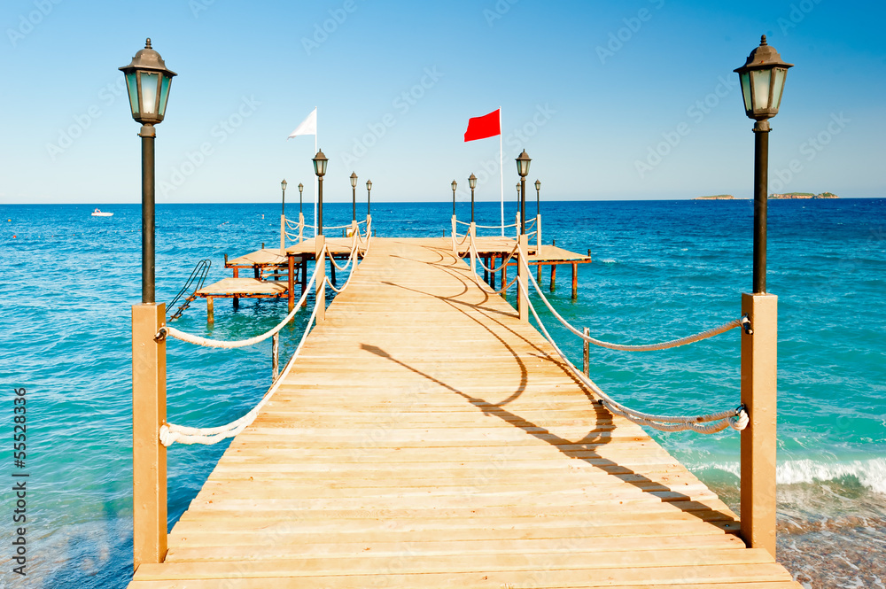 light poles and rope fence on wooden pier