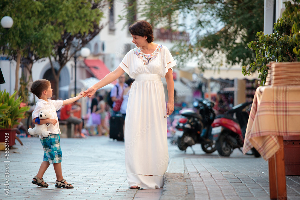 Fototapeta premium Mother and her little son walking in city
