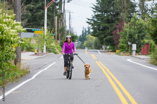 woman riding bike with a dog