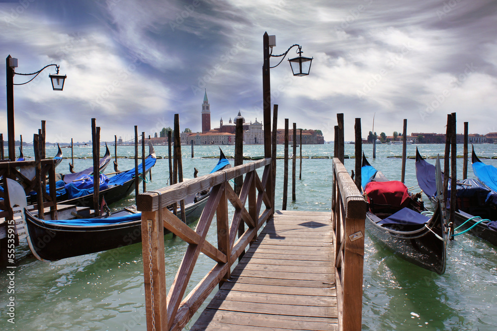 Venice lagoon. Gondolas moored by Saint Mark square with San Gio