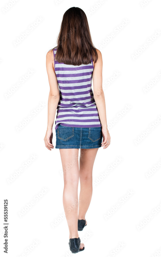 back view of walking  woman in jeans dress .
