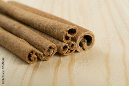 Cinnamon sticks over wooden background close up