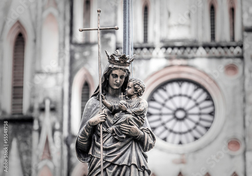 Marble statue of the virgin Mary carrying a child with a diffuse