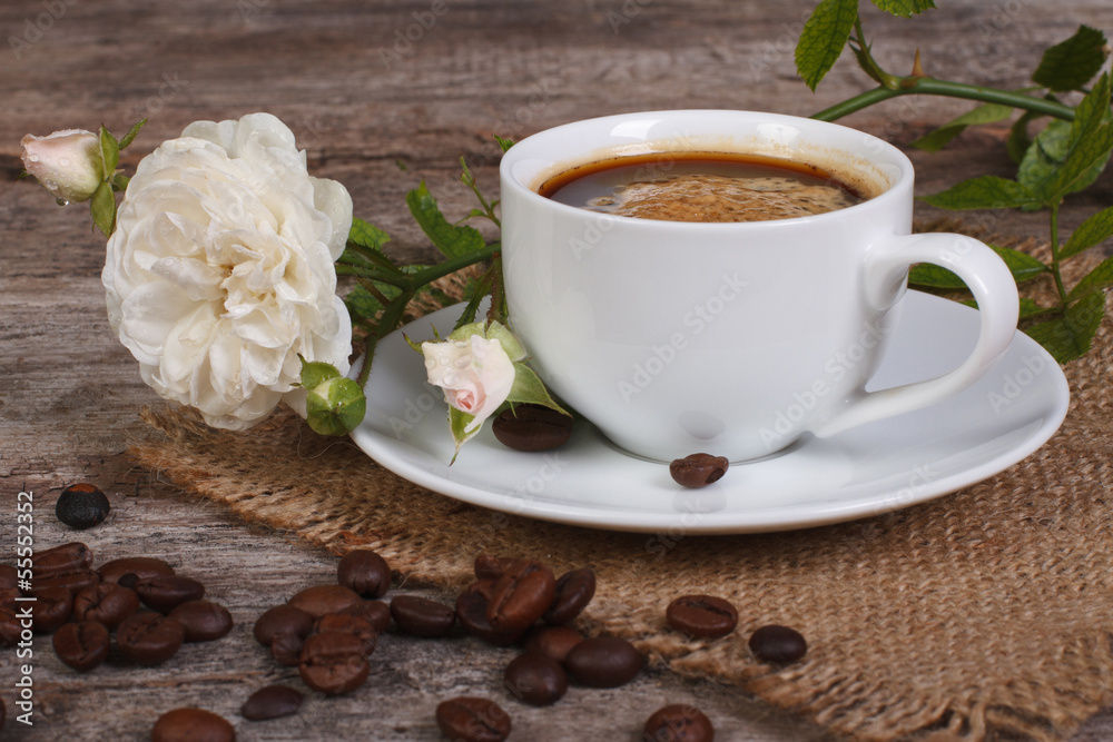 Black coffee on the table and a white rose flower Black coffee on the table and a white rose flower