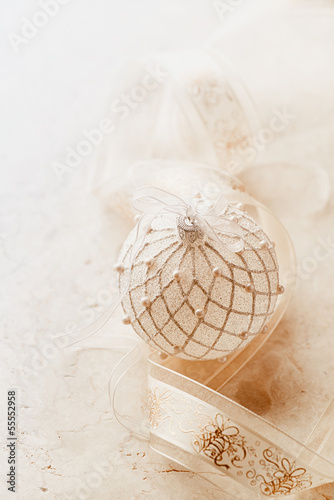 Christmas ball and satin ribbon on marble background