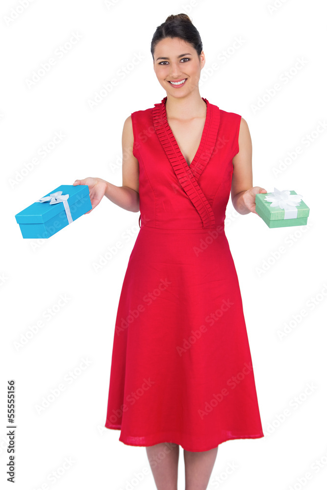 Smiling glamorous model in red dress holding presents Smiling glamorous model in red dress holding presents