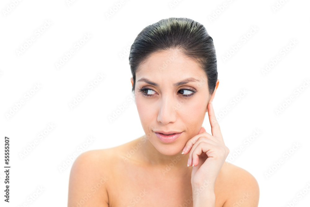Smiling brunette looking away with finger on her face