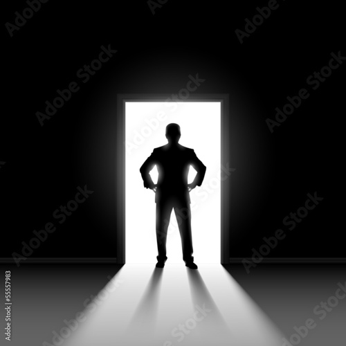 Silhouette of man standng in doorway.