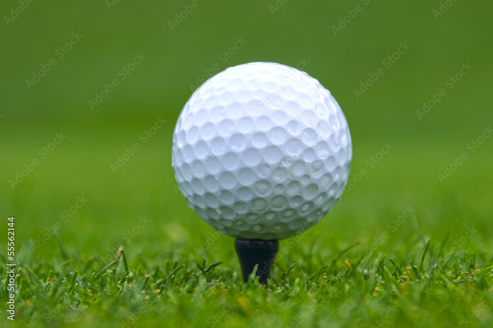 Closeup of white golf ball on black tee Closeup of white golf ball on black tee