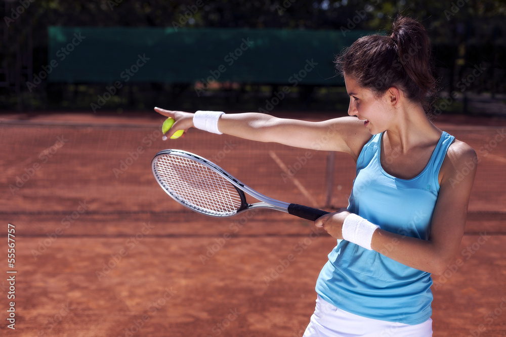 Young girl playing tennis on court