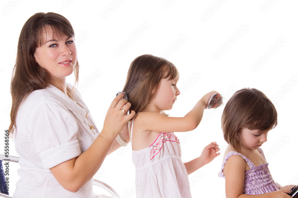 Mother and two daughters combing hair to each othre Mother and two daughters combing hair to each othre