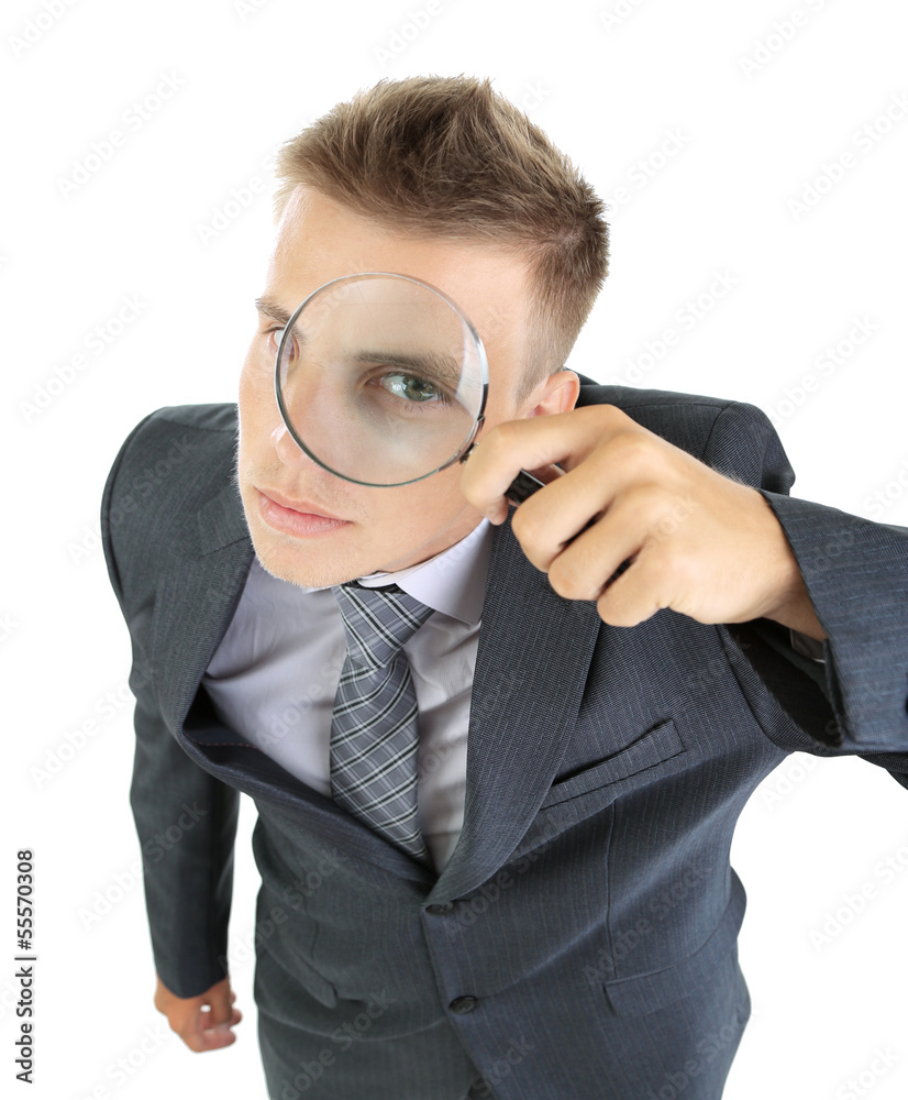 Young businessman looking through magnifying glass isolated Young businessman looking through magnifying glass isolated