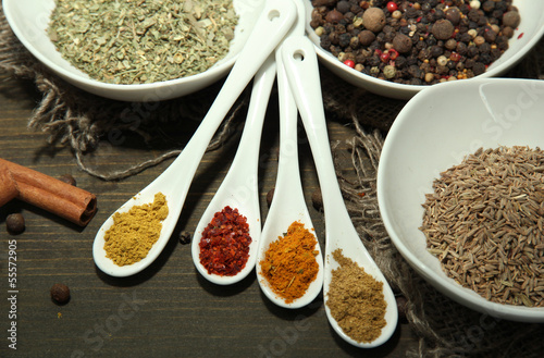Assortment of spices in  white spoons and bowls,