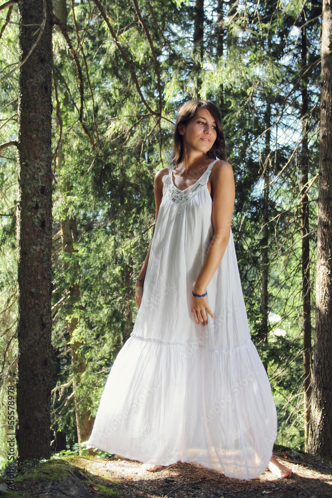 Beautiful young woman white dressed in the forest