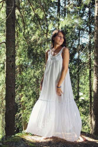 Beautiful young woman white dressed in the forest