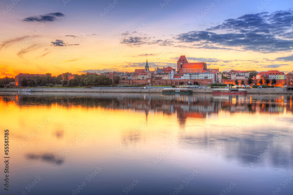 Torun old town reflected in Vistula river at sunset, Poland