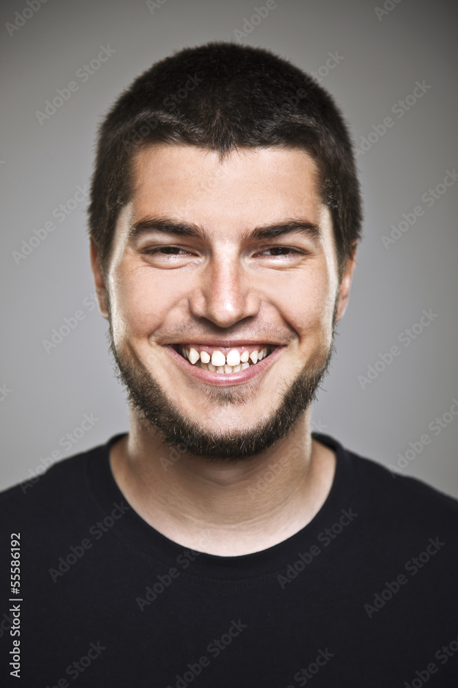 Portrait of a real smiling man over grey background. Portrait of a real smiling man over grey background.