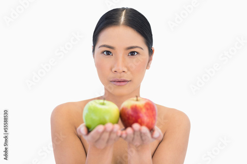 Content natural brunette holding apples in both hands
