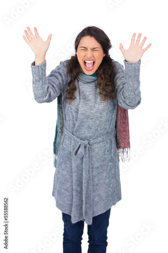 Angry pretty model with winter clothes screaming