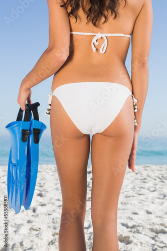 Perfect feminine buttocks of slim young woman holding fins
