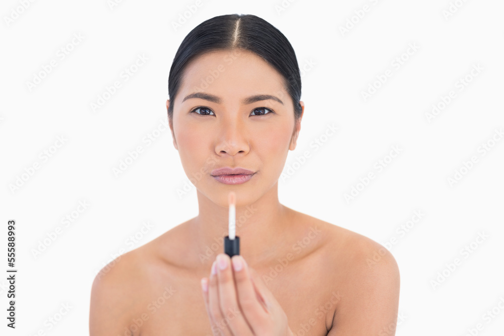 Calm attractive model holding lip gloss Calm attractive model holding lip gloss