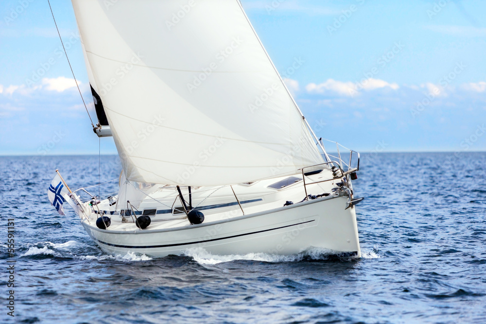 Sailing boat on open sea sailing on port tacks