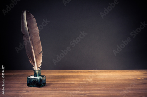 Vintage background with quill pen and inkwell on table