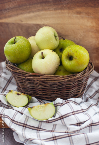 Fresh apples in basket on table