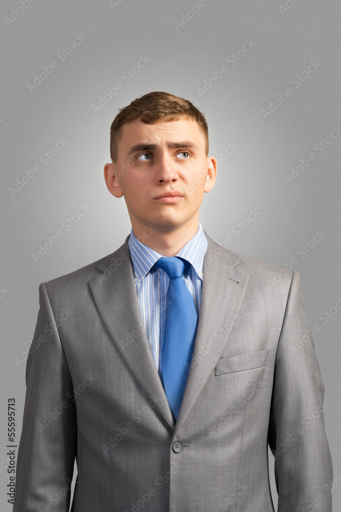 young businessman thinking and looking up young businessman thinking and looking up