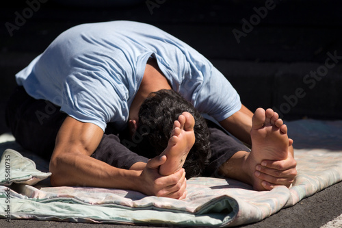 Valokuva Jeune homme souple s'étirant au sol.