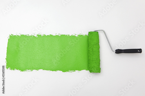 Quadro su tela Green paint roller on white background