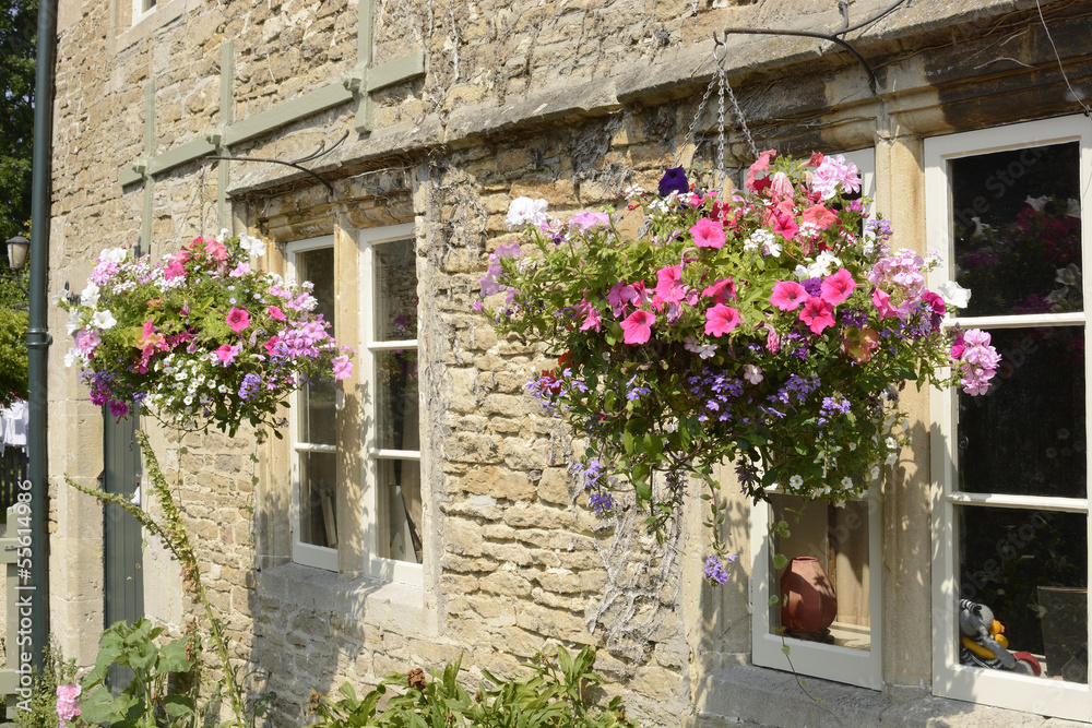 Cottage with hanging flower baskets. Wiltshire. England