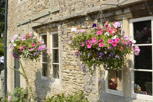Cottage with hanging flower baskets. Wiltshire. England