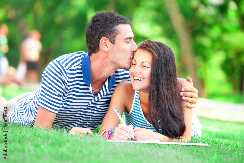 Young students sitting on green grass with note book. Young students sitting on green grass with note book.