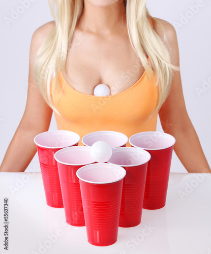 Beer pong. Red cups with ping pong ball and sexy blonde girl