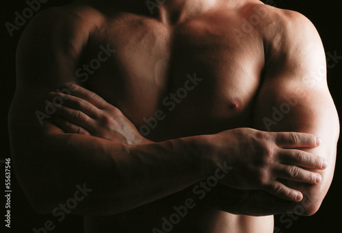 Healthy muscular young man. Isolated on black background