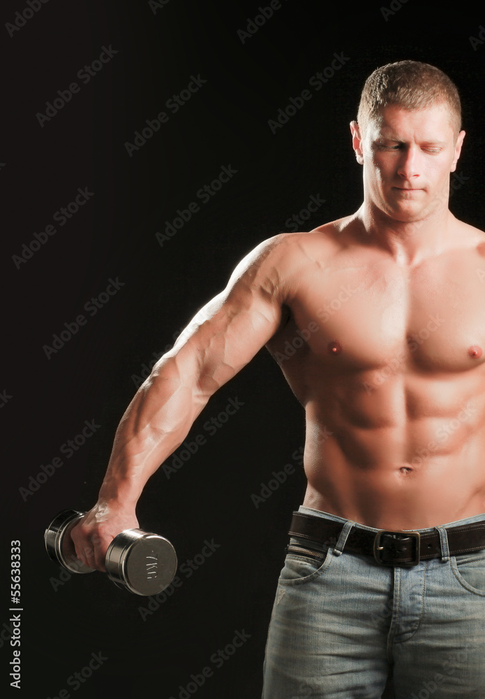 Handsome muscular man working out with dumbbells Handsome muscular man working out with dumbbells