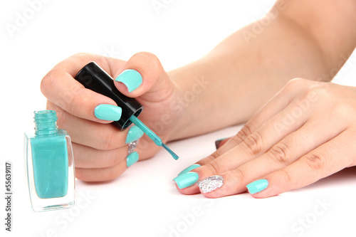 Beautiful woman hands with blue manicure isolated on white