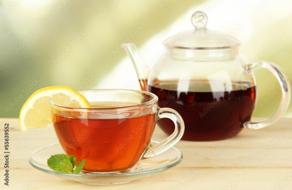 Cup of tea with lemon on table on light background Cup of tea with lemon on table on light background
